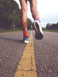 Low section of man walking on road