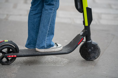 Low section of person on push scooter on street