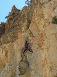 Low angle view of woman standing on cliff