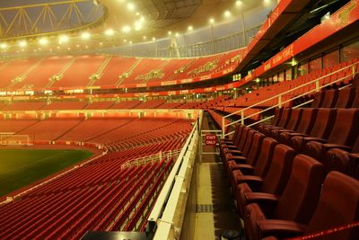 Empty seats in illuminated stadium at night