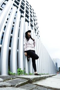 Full length of woman standing against sky in city