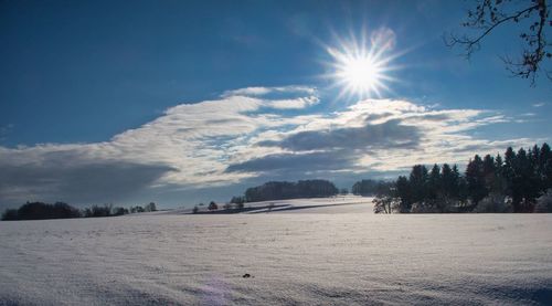 Scenic view of snowcapped field against sky