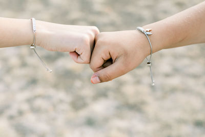 Cropped hand of friends fist bumping 