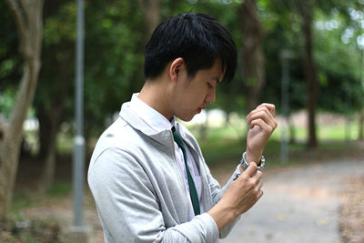 Side view of young man looking at camera