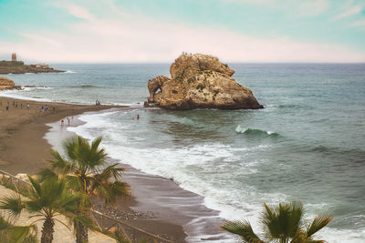 People at the mediteranean beach on a hazy day. penon del cuervo. costa del sol, malaga, spain