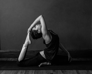 Woman sitting in front of wall