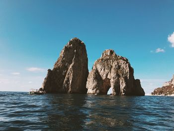 Rock formations in sea against sky