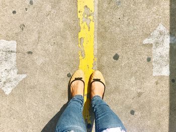 Low section of woman standing on road