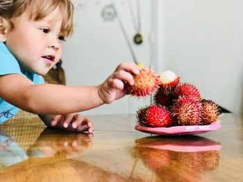 Boy with fruits on table