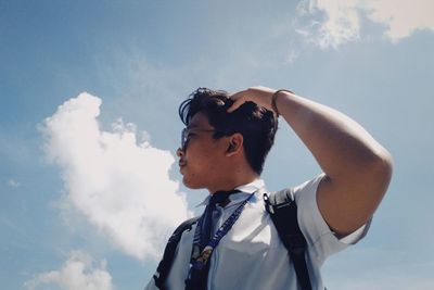 Low angle view of man looking away against sky