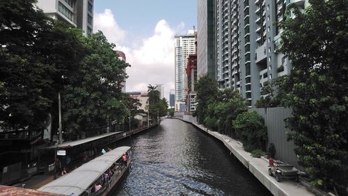 Canal amidst buildings in city against sky