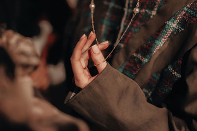 Female hand holding a gold chain