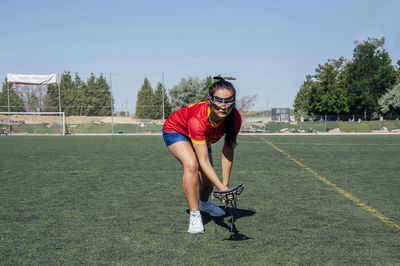 Young player playing lacrosse on sports field