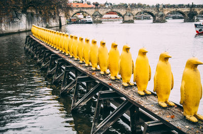 Statues on pier at river