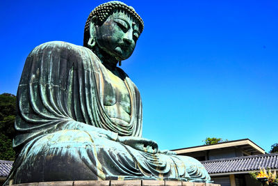 Low angle view of statue against blue sky