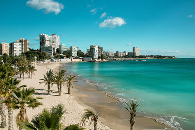 Scenic view of sea and buildings against blue sky