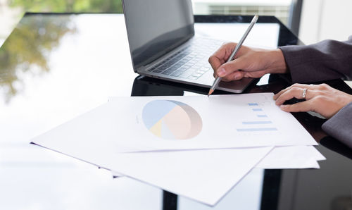 Close up hands writing of young and smart business woman manager who is working on data analysis 