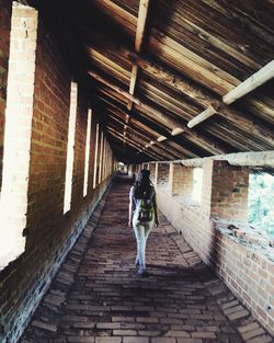 Rear view of woman walking on footbridge