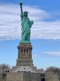 Low angle view of statue of liberty against sky