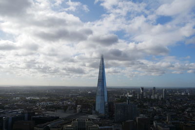 Buildings in city against cloudy sky