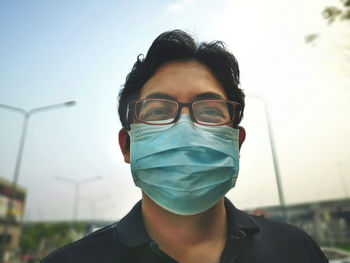 Portrait of man wearing gas mask against sky