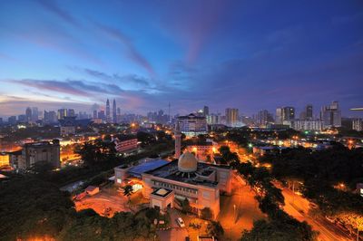 High angle view of illuminated cityscape against sky at night