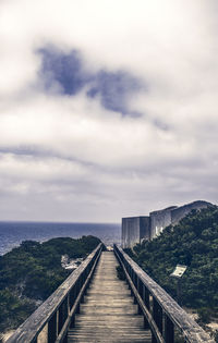 View of pier on sea against cloudy sky