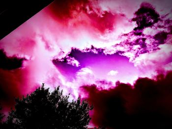 Low angle view of silhouette trees against dramatic sky