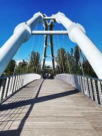 View of footbridge against blue sky