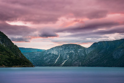 Scenic view of lake and mountains against sky during sunset