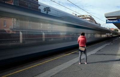 Rear view of man walking on railroad station platform