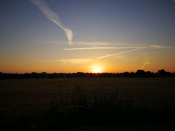 Scenic view of field against sky at sunset