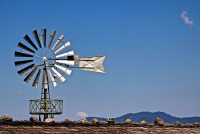 Traditional metallic windmill against sky