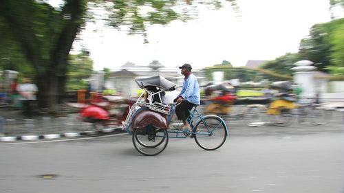 Man with bicycle on road in city