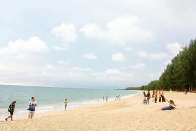 People at beach against sky