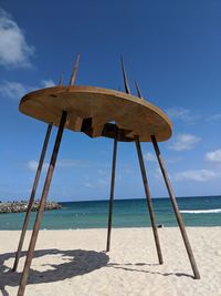 Lifeguard hut on beach against blue sky