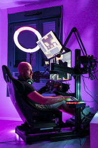 Bald male gamer playing video game at studio