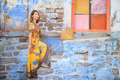 Portrait of woman against brick wall