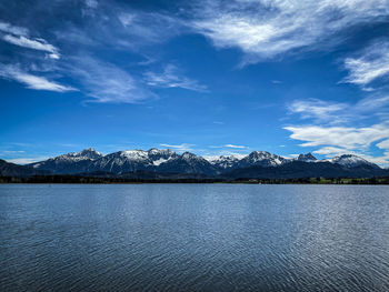 Scenic view of lake by mountains against sky