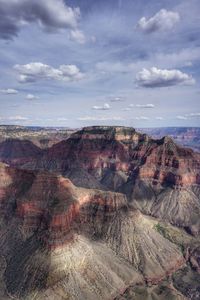 Rock formations on landscape against cloudy sky