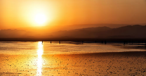 Scenic view of beach against sky during sunset