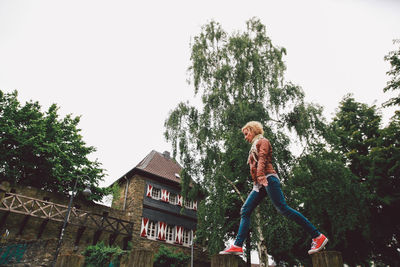 Low angle view of woman standing on tree