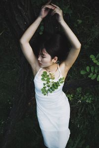 High angle view of woman standing by tree in forest