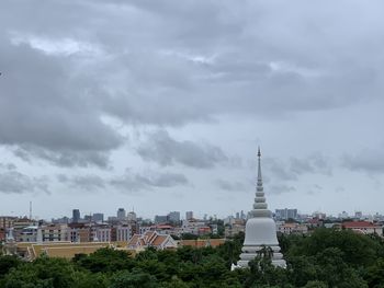 Buildings in city against cloudy sky