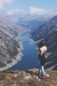 Woman standing on mountain against sky