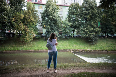 Full length of woman standing by trees