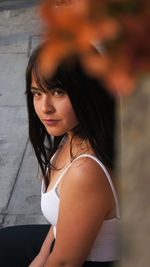 Portrait of beautiful young woman sitting outdoors