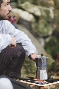 A man prepares coffee outdoors