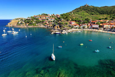 High angle view of townscape by sea against sky