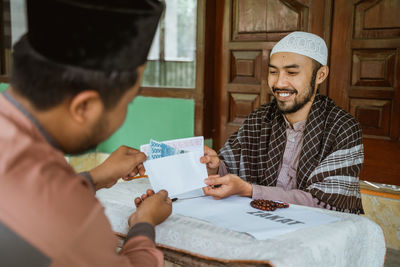 Young man doing charitable donation at mosque